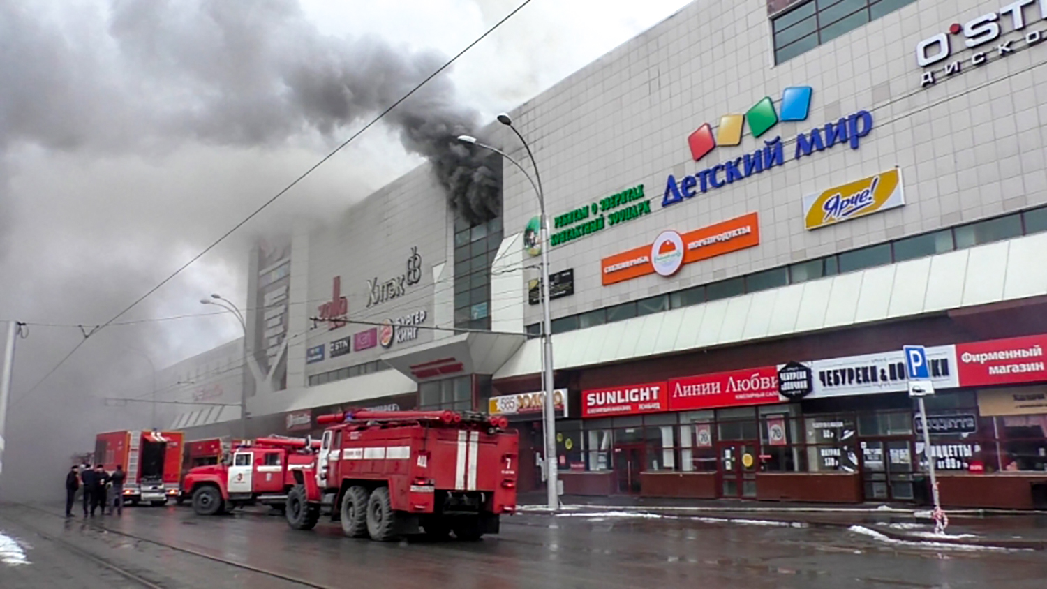 This handout picture released by The Russian Emergency Situations Ministry on March 25, 2018, shows emergency vehicles as they gather outside a burning shopping centre in Kemerovo. Five people including a child have died and another 30 were wounded in a major fire in a Siberian shopping centre, Russia's Investigative Committee said. "Three women, a child and a man have been killed" and 30 people hospitalised following the blaze in the Winter Cherry shopping centre in Kemerovo, an industrial city in central Siberia, it said in a statement.  / AFP PHOTO / RUSSIAN EMERGENCY SITUATIONS MINISTRY / HO / RESTRICTED TO EDITORIAL USE - MANDATORY CREDIT "AFP PHOTO / RUSSIAN EMERGENCY SITUATIONS MINISTRY" - NO MARKETING NO ADVERTISING CAMPAIGNS - DISTRIBUTED AS A SERVICE TO CLIENTS. RUSSIA'S EMERGENCY SITUATIONS MINISTRY
