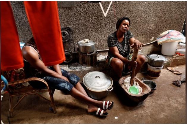 Honrne Waba, 40, who has fled the northwestern village of Njinikom because of violence, cooks as her son-in-law sits in the courtyard of the house where she is staying in Yaounde, Cameroon, October 3, 2018. REUTERS/Zohra Bensemra