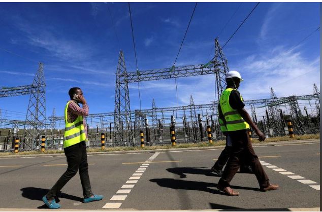 Kenya Electricity Generating Company (KenGen) workers walk past the pylons of high-tension electricity power lines at the Olkaria II Geothermal power plant near the Rift Valley town of Naivasha, Kenya February 15, 2018. REUTERS/Thomas Mukoya