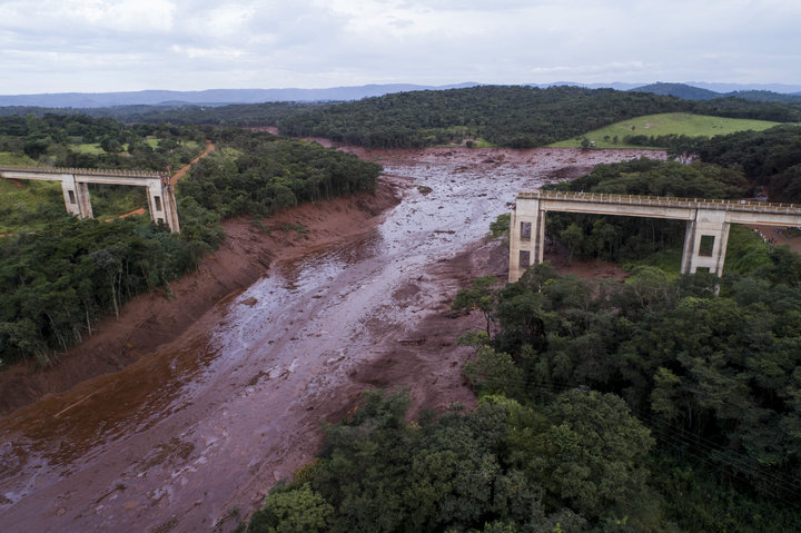 An aerial view shows a collapsed bridge caused by flooding triggered by a dam collapse near Brumadinho, Brazil, Friday, Jan. 25, 2019. The dam that held back mining waste collapsed, inundating a nearby community in reddish-brown sludge, killing at least seven people and leaving scores of others missing. (Bruno Correia/Nitro via AP)