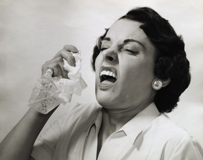 (Original Caption) Picture shows a woman about to sneeze holding a handkerchief in her hand. Undated photo.