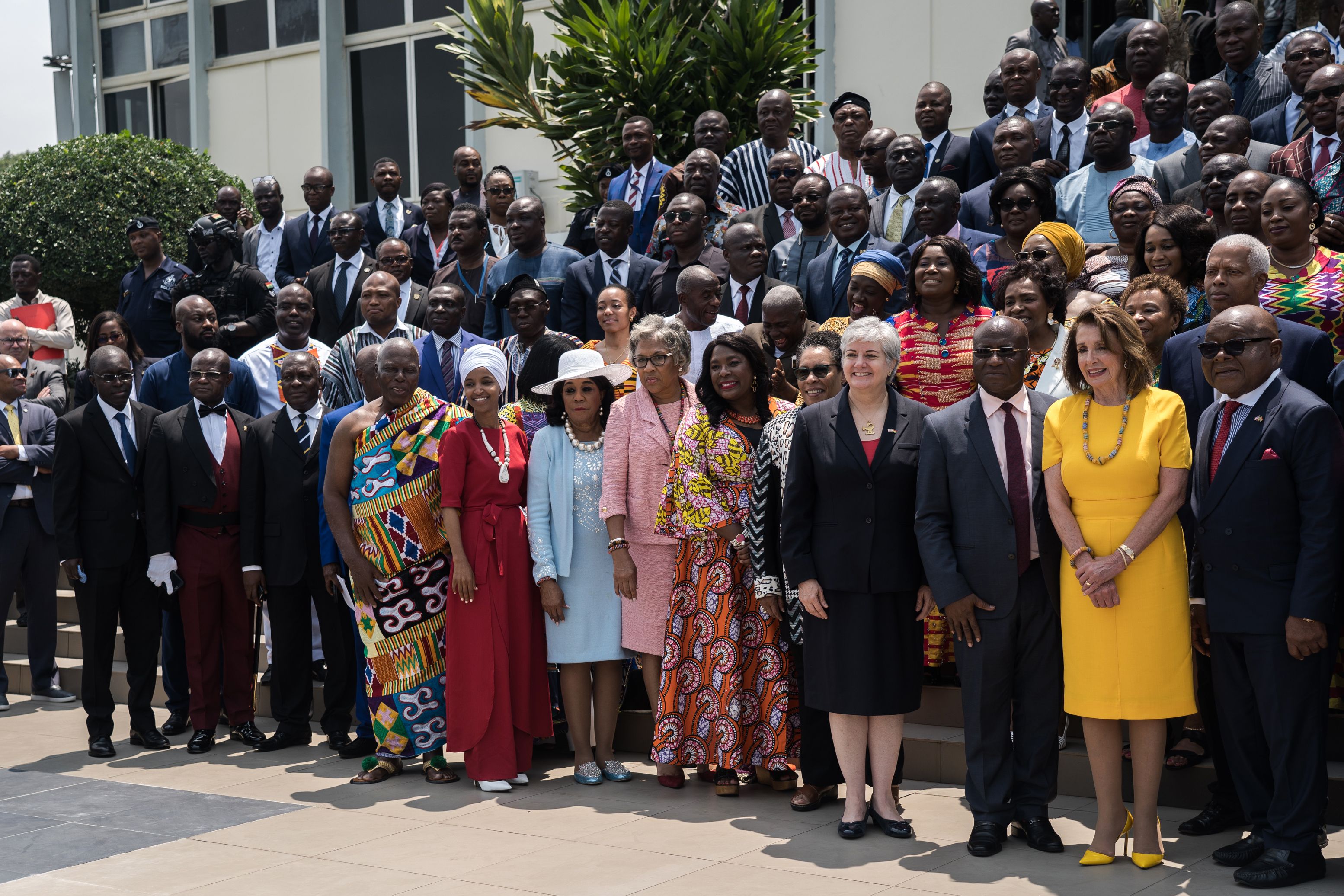 US Speaker of the House Nancy Pelosi (2nd R), Speaker of Ghana's Parliament Mike Aaron Oquaye (R) and US Representative Ilhan Omar (5th L) pose for a family picture with members of Parliament in front of the Ghana's Parliament in Accra, on July 31, 2019 during a three-day visit to the country to mark the 400 years anniversary since the first slave shipment left the Ghana's coast for United States. - US House Speaker Nancy Pelosi condemned the "grave evil" of slavery in a speech to Ghana's parliament marking 400 years since the first shipment of enslaved Africans to America. Pelosi was leading a delegation including members of the Congressional Black Caucus to the West African country, four centuries after the first slave ship arrived in Jamestown, Virginia from the continent. (Photo by Natalija GORMALOVA / AFP)        (Photo credit should read NATALIJA GORMALOVA/AFP/Getty Images)