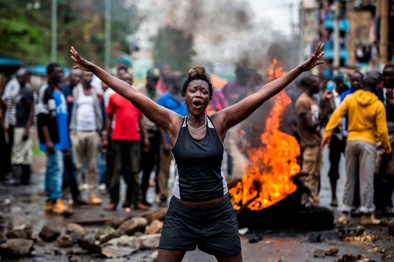 An opposition supporter in front of a burning barricade in Nairobi on Oct. 26. Photographer: Luis Tato/AFP via Getty Images