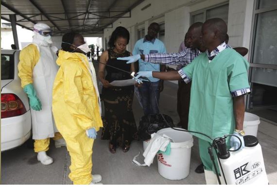 A health worker sprays a colleague with disinfectant during a training session for Congolese health workers to deal with Ebola virus in Kinshasa October 21, 2014. REUTERS/Media Coulibaly