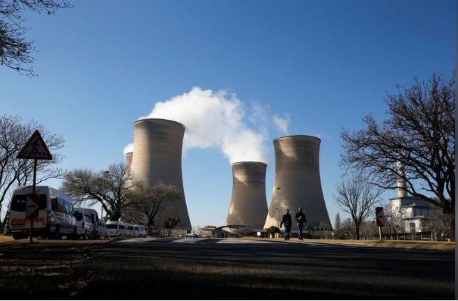 Workers are seen near cooling towers of the Hendrina power station, located south of Middelburg, South Africa, July 13, 2018. Picture taken July 13, 2018. REUTERS/Siphiwe Sibeko