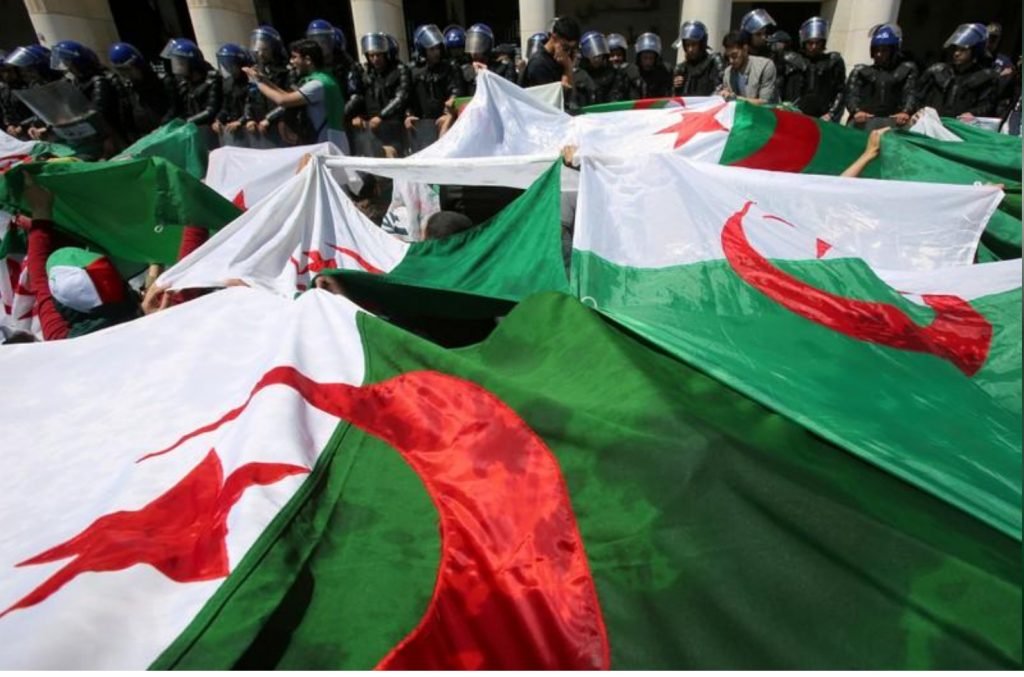 Police members stand guard as students carry national flags during an anti-government protest in Algiers, Algeria May 14, 2019. REUTERS/Ramzi Boudina/File Photo